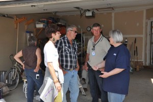 -Janet Plenert, MDS Region V Manager, Peter Goertzen and Garry Wiens, MDS Alberta Unit members, talk with Ms. Wall, a homeowner in Black Diamond.