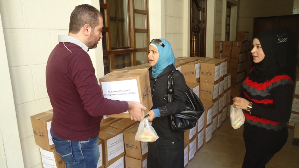 n Damascus, a woman accepts a box of food supplied by MCC through its partner, the Syrian Orthodox Church. She is not identified for security reasons. Photo courtesy of the Syrian Orthodox Church