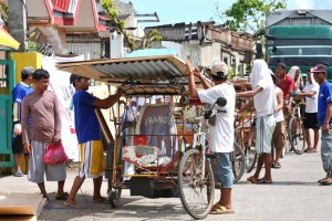 MCC is supplying building materials, including plywood and tin sheets similar to those being loaded onto this bicycle-powered rickshaw, to almost 3,000 families whose homes were destroyed by Typhoon Haiyan. In addition, MCC is paying local people to build the houses in the towns of Naval and Dulag.   MCC Photo by Laura Armstrong.