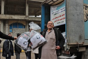 Ismael shows the bags of winter clothing he received from MCC through its partner Zakho Small Villages Project in Iraq. His family was among those displaced more than a year ago by the Islamic State group. His last name was withheld for security reasons. (MCC Photo)