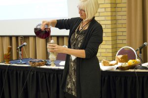 Mary Anne Isaak prepares communion elements during the evening worship session at MCC Canada’s 2016 annual general meeting. MCC photo/Rachel Bergen